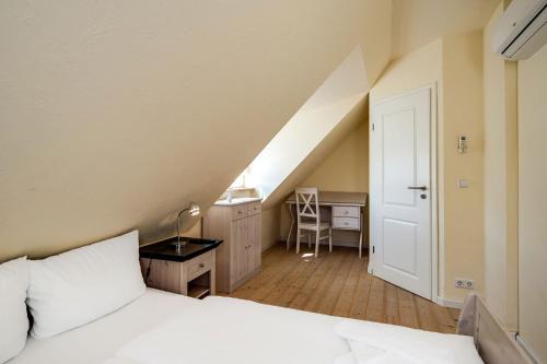 a bedroom with a white bed and a desk at Heideröschen Park Heideröschen 5c in Zingst