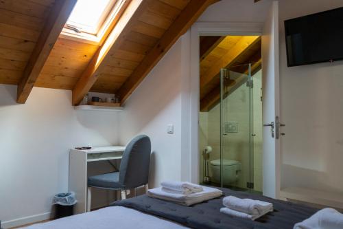 a bedroom with a bed and a desk and a chair at Casa do Chafariz in Cercal