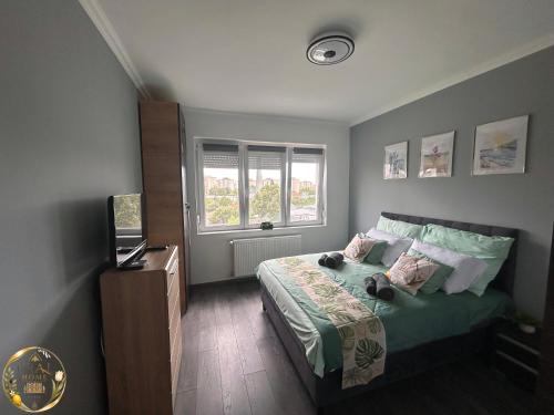 a bedroom with a bed and a television in it at Ural Home in Székesfehérvár