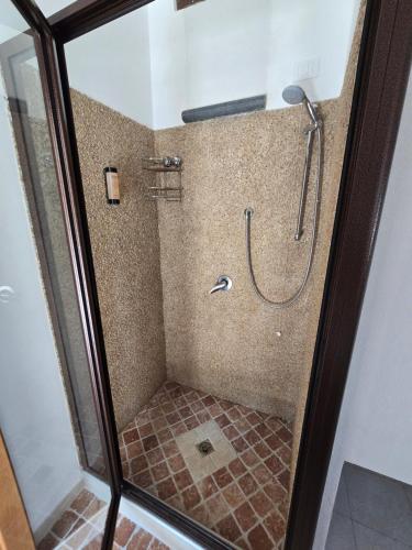 a shower stall with a glass door with a shower at Santo Re Olive Retreat in Petrizzi
