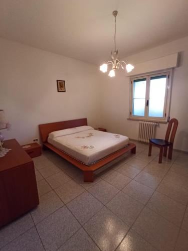 a bedroom with a bed and a table and a window at Tra mare e vigneti in Ortona