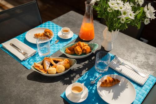 a table with plates of pastries and cups of coffee at Residence San Marco Suites&Apartments Alassio in Alassio