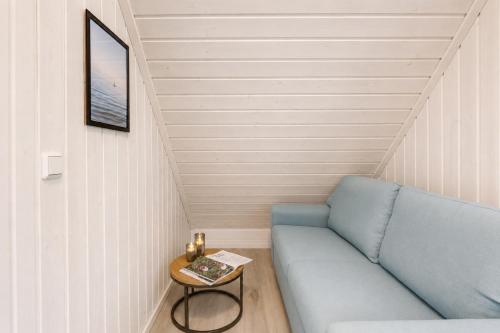 a small room with a blue couch and a table at Schiller in Wandlitz