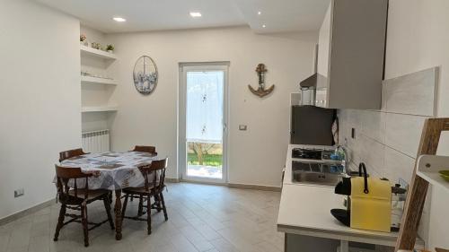 a kitchen with a table and a kitchen with a table and chairs at Alloggio Turistico Francy House in Lido dei Pini