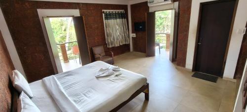 a bedroom with a white bed and a hallway with sliding doors at Hotel Casa viora at swimming pool in Calangute