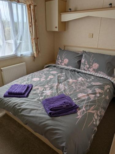 a bed with purple towels on it in a bedroom at Ocean View in Aberaeron
