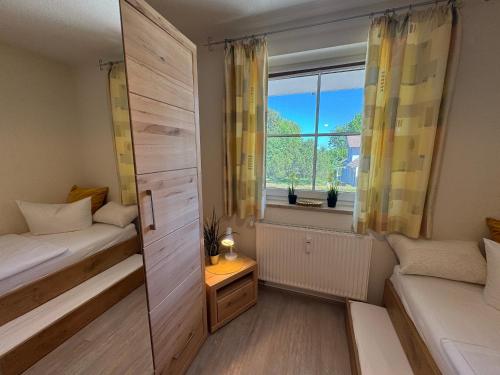 a small room with two beds and a window at Altes Wasserwerk App 20 in Wustrow