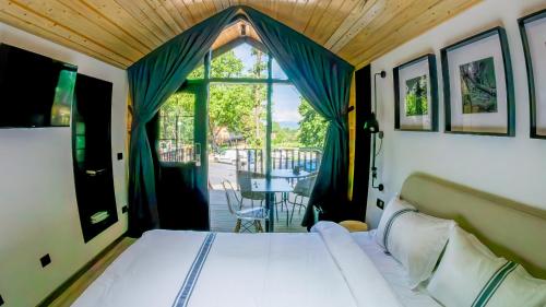 a bedroom with a bed and a large window at Casa Roben in Râu de Mori