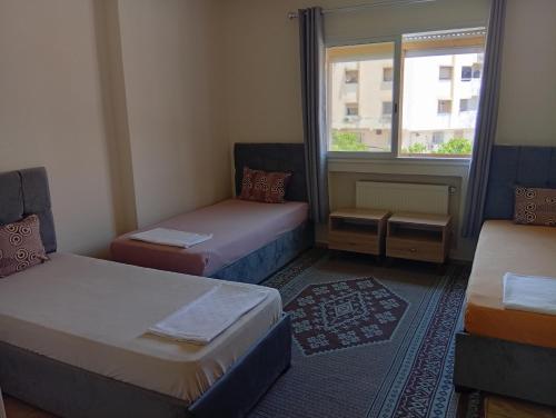 a small room with two beds and a window at Paradise Rose in Sfax