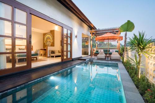 a swimming pool in a villa with a house at Dijero at Umah Bali in Ubud