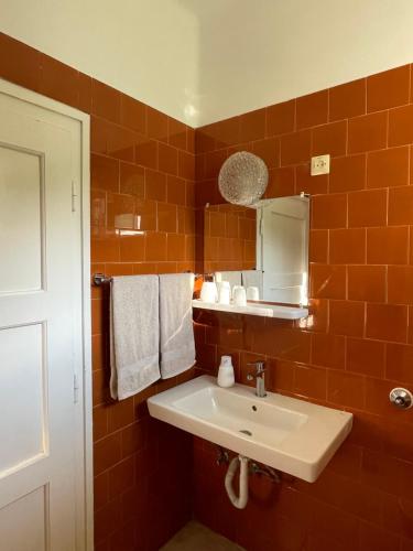 a bathroom with a white sink and orange tiles at Zongorás Apartman in Balatonalmádi