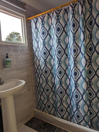 a bathroom with a shower curtain and a sink at La Bella Vista in Calarcá