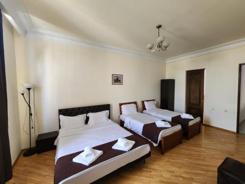 a bedroom with two beds and a ceiling at Nana Grand Hotel Yerevan in Yerevan