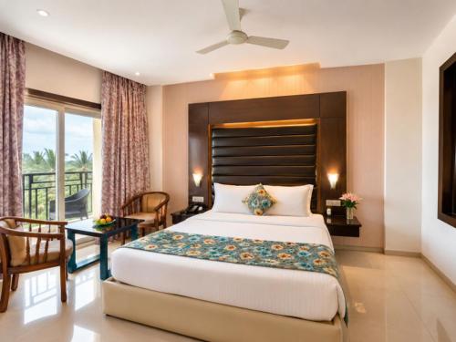a bedroom with a large bed and a balcony at Golden Palace Puri - Private Flagship Beach - Swimming Pool - Sea View Rooms - Restaurant - Luxurious Stay in Puri