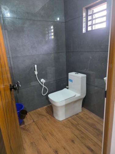 a bathroom with a white toilet in a room at Ruby Residency in Perintalmanna