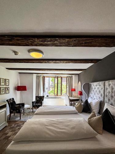 a bedroom with a large bed and a large window at Hotel Herrnschloesschen in Rothenburg ob der Tauber