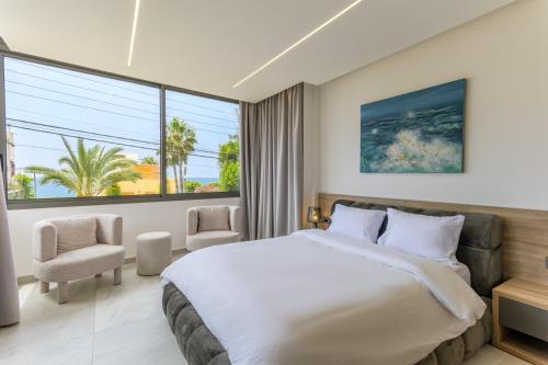 a bedroom with a large bed and a large window at Cavella Apart Hotel in Monsef in Al Ḩulwah