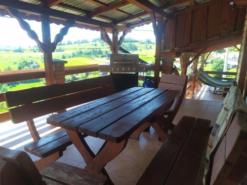 a wooden table and benches in a room with a view at Agroturystyka Ela in Rzepiska