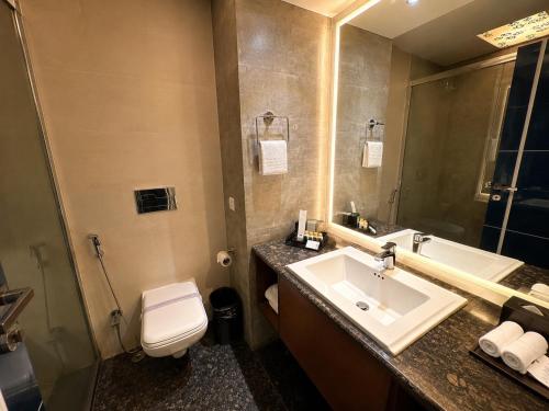 a bathroom with a sink and a toilet at Golden Palace Puri - Private Flagship Beach - Swimming Pool - Sea View Rooms - Restaurant - Luxurious Stay in Puri