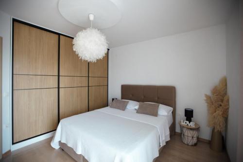 a bedroom with a large white bed and a chandelier at Ana & Marija in Kaštela