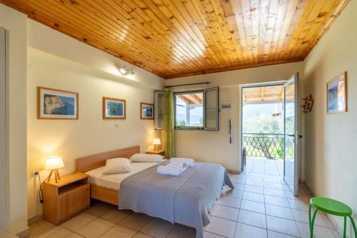 a bedroom with a bed and a wooden ceiling at Matina Studios in Nikiana
