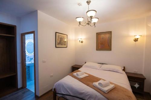 a bedroom with a bed with two towels on it at Vila e Mjeshtrit in Korçë