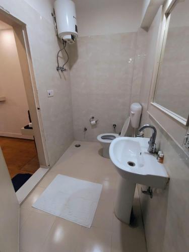 a white bathroom with a sink and a toilet at Hotel Samrat - A Boutique Hotel in Prayagraj