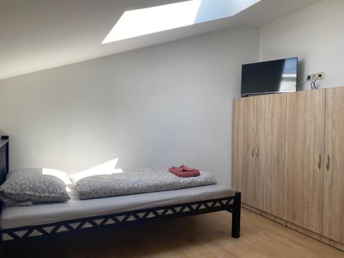 ein Schlafzimmer mit einem Bett und einem Holzschrank in der Unterkunft 3 Elementy in Čachtice