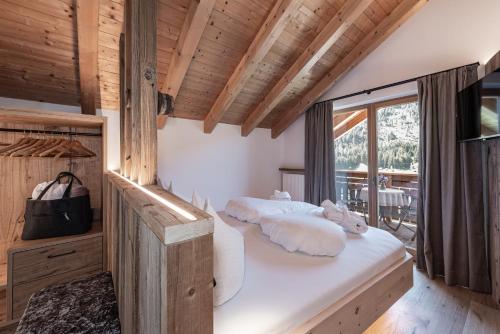 a bedroom with two beds and a balcony at Oberkantiolhof in Villnoss