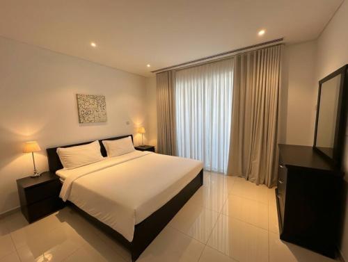 a bedroom with a bed and a large window at Thewalk2 Pool View ~ 5 mins from Airport in Seeb
