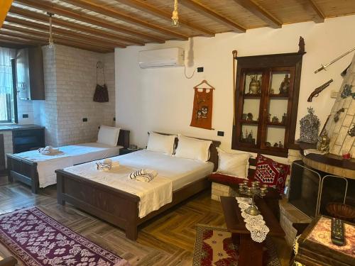 a bedroom with two beds and a couch and a piano at Guest House Iljesa in Berat
