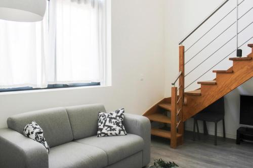 a living room with a couch and a staircase at Stunning Bright Duplex in Saint-Ouen