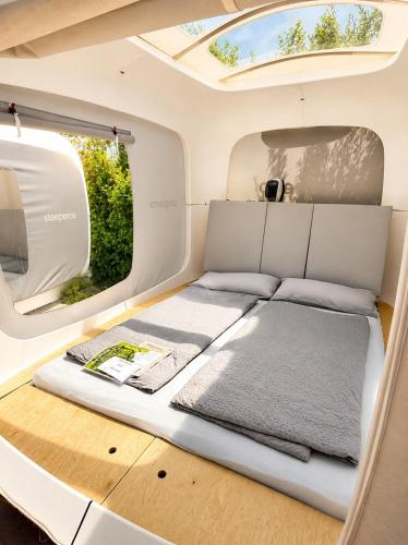 a bed in the back of an rv with a window at Cubes am Irrsee - SELF CHECK-IN in Sommerholz