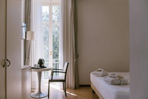 a bedroom with a bed and a desk and a window at Grand Hotel Telese in Telese