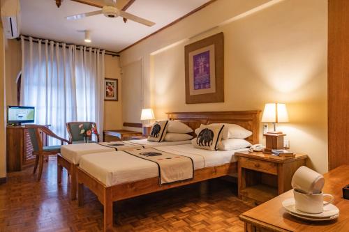 ein Hotelzimmer mit einem Bett und einem Tisch in der Unterkunft Hotel Casamara - Center Point Kandy in Kandy