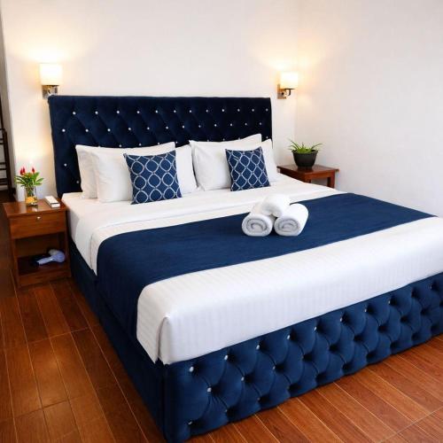 a bedroom with a large bed with two towels on it at Ceylan Crest in Ella