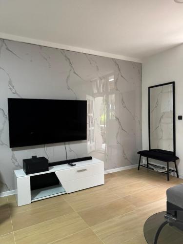 a living room with a flat screen tv on a wall at Hide Avenue Dedinje in Dedinje