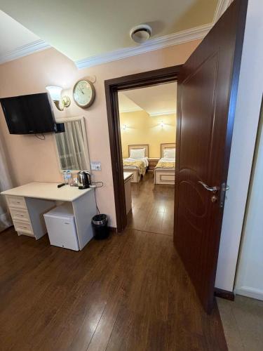 a room with a desk and a clock on the wall at The House Hotel Goris in Goris