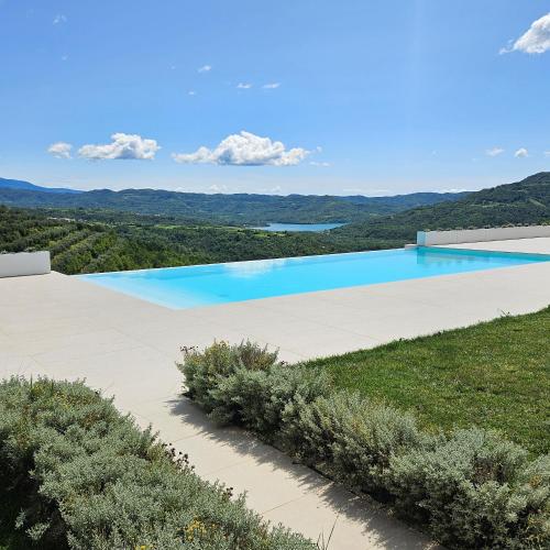 a swimming pool with a view of the mountains at Villa with Private Pool & Lake View near Motovun, Casa Mille Olivi Heritage in Buzet