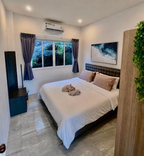 a bedroom with a large bed with two towels on it at Keya Mountain View Pool Villa Samui in Ban Thung