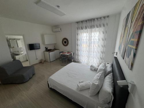 a bedroom with a bed and a chair and a window at La Marina Rooms HOWME in Torre a Mare