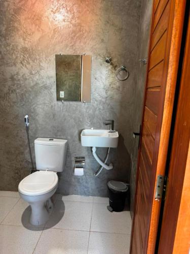a bathroom with a toilet and a sink at Casa Annas - Conforto e Tranquilidade in Icaraí