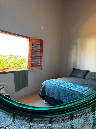 a bedroom with a bed and a large window at Casa Annas - Conforto e Tranquilidade in Icaraí