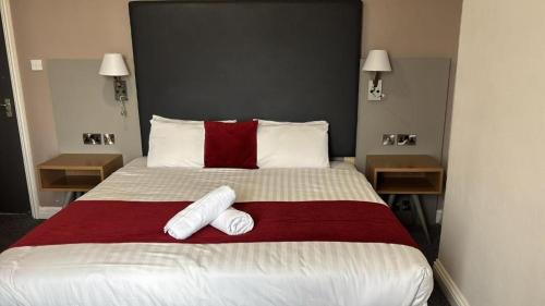 ein Schlafzimmer mit einem großen Bett, auf dem zwei Handtücher liegen in der Unterkunft Midland Hotel in Mansfield