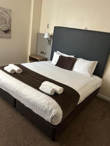 ein Schlafzimmer mit einem großen Bett, auf dem zwei Handtücher liegen in der Unterkunft Midland Hotel in Mansfield