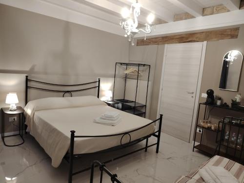 a white bedroom with a bed and a chandelier at Domus Mater in Vigonza