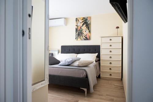 a bedroom with a bed and a dresser at Domus Home Ladispoli in Ladispoli