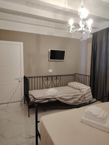 a bedroom with two beds and a tv on the wall at Domus Mater in Vigonza
