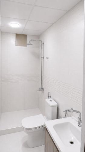 a white bathroom with a toilet and a sink at Starry Nights Camp in Wadi Rum