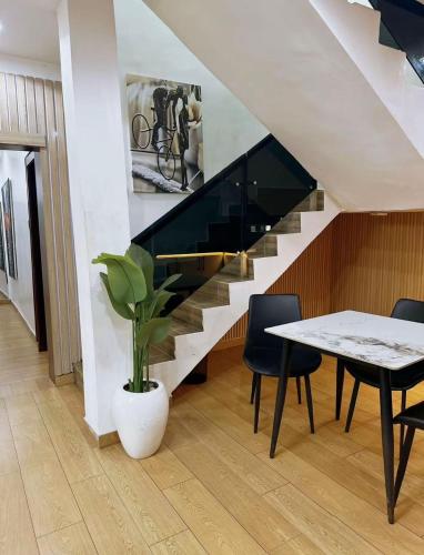 a dining room with a table and a staircase at North Unit in Asaba